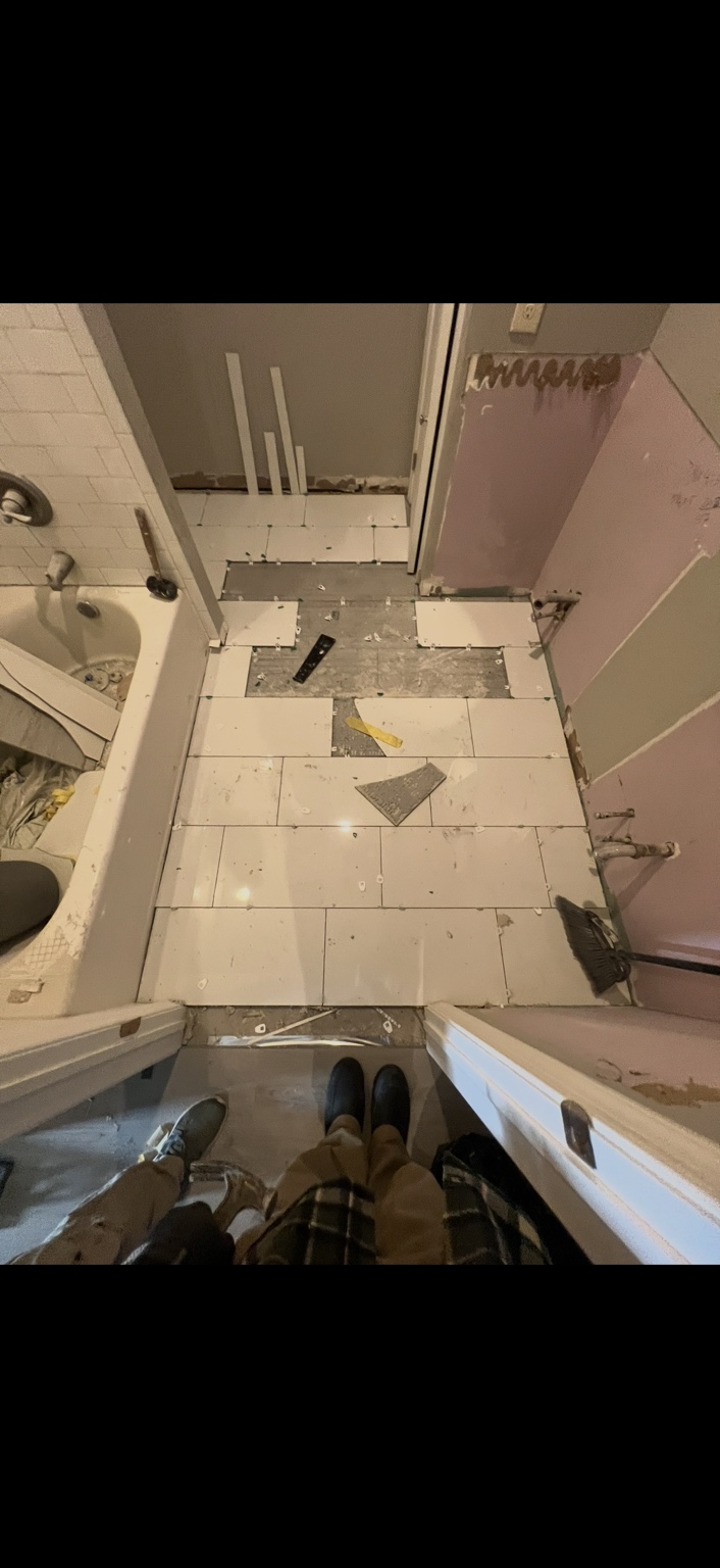 Bathroom floor after tile installation with spacers in place